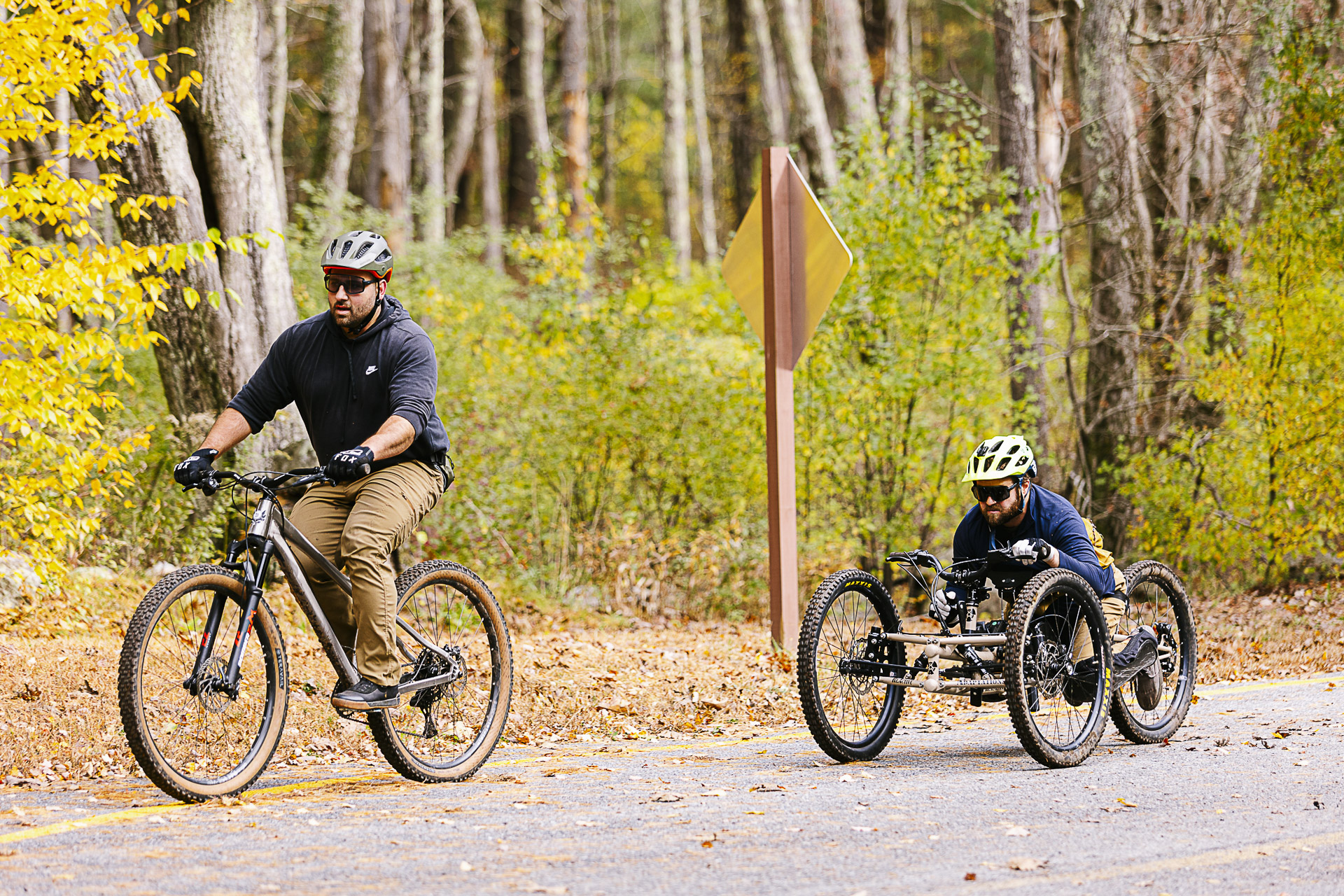 A mountain biker and an adaptive rider on a four-wheel adaptive mountain bike ride side by side